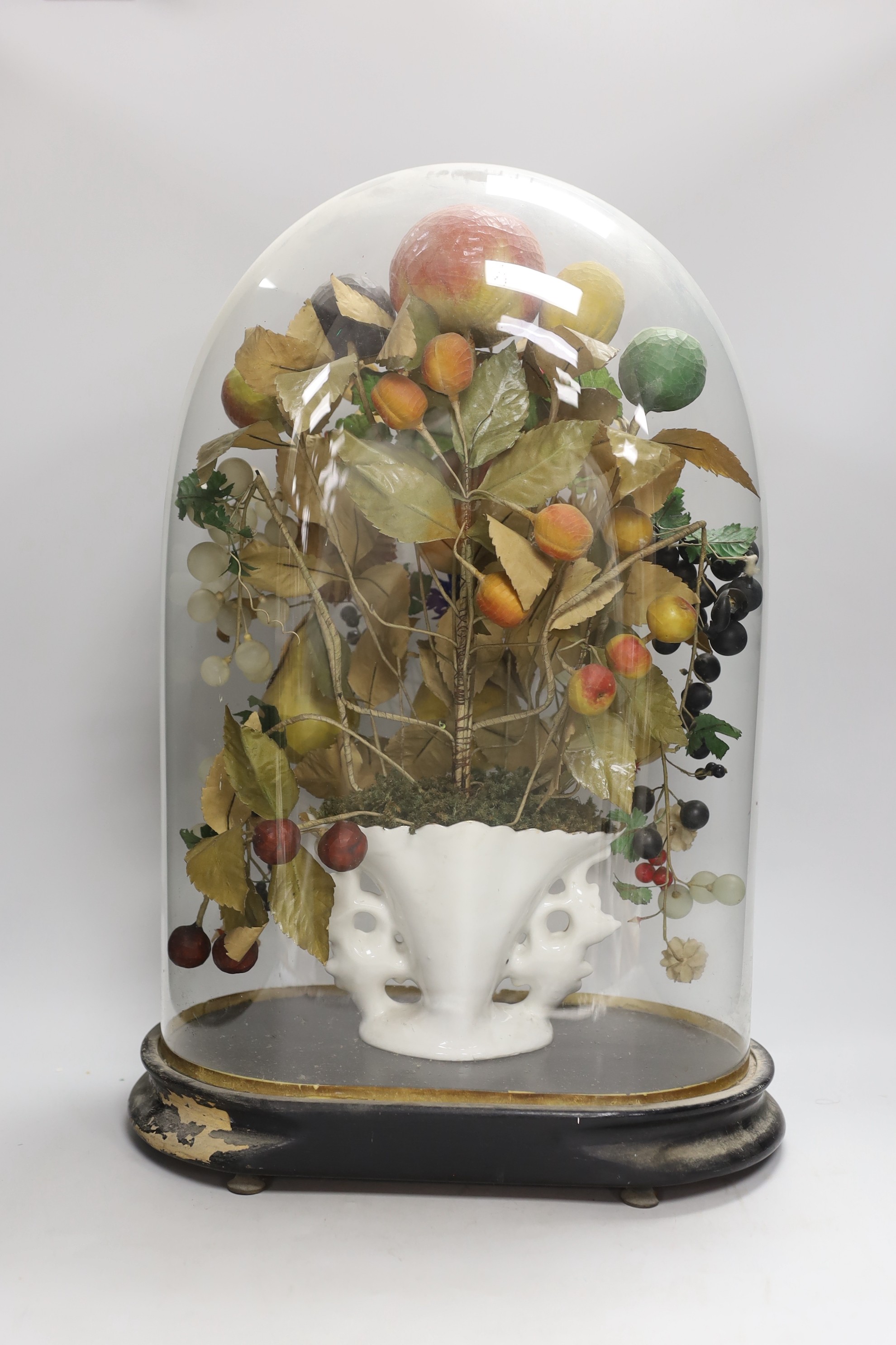 A Victorian painted mache fruit arrangement under a glass dome, 52cms high